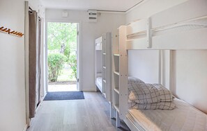 Ein Zimmer mit Etagenbetten, einer Tür, die nach draußen führt, und einer kleinen Matte am Eingang.