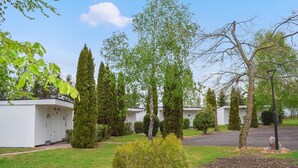 A row of white mobile homes with a well-maintained lawn and trees. - Beautiful home in Ystad (Ystad)