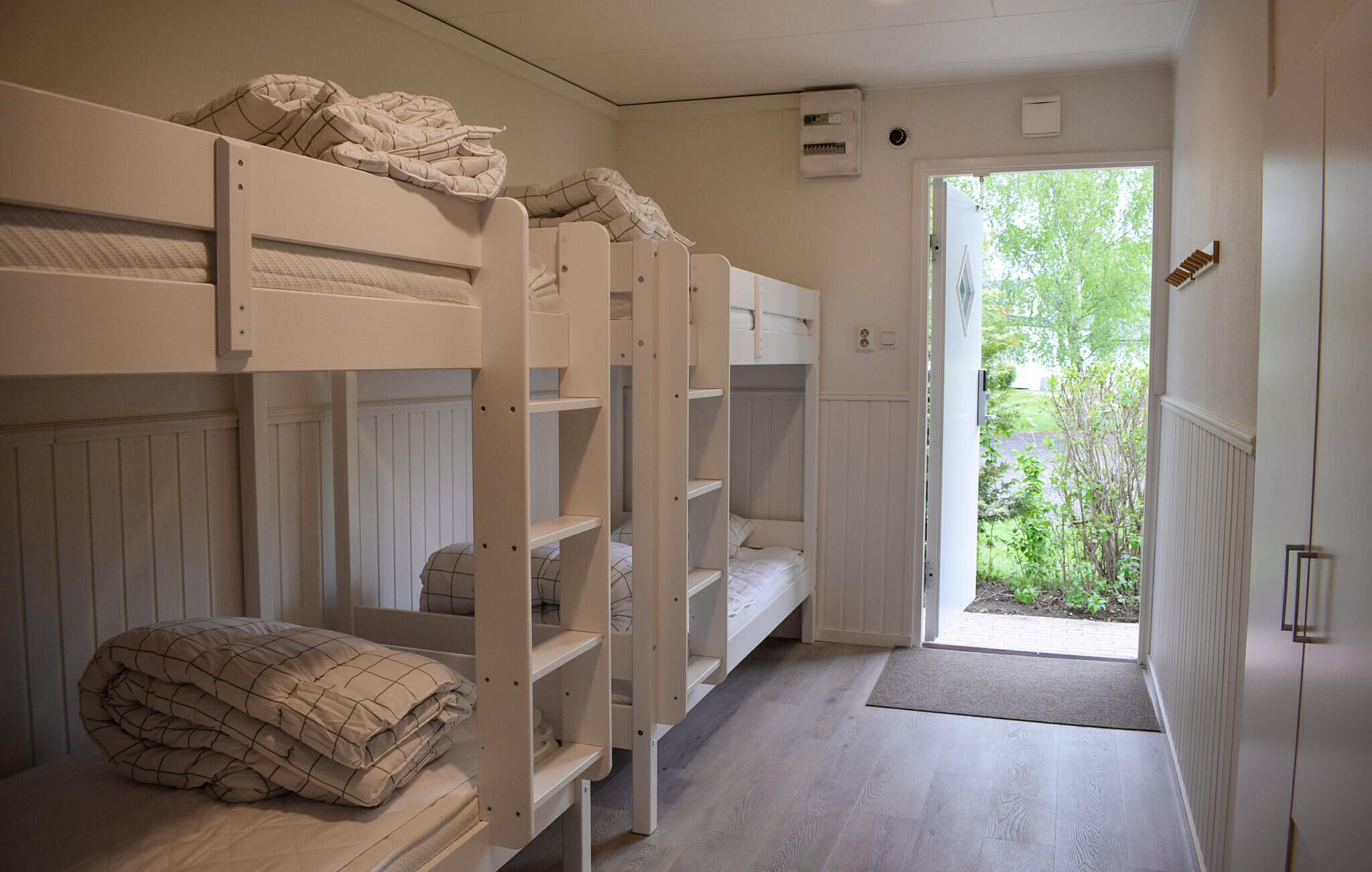 Dormitorio con literas y puerta que da a un jardín.