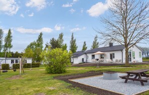 Un barrio residencial con una casa blanca, una mesa de picnic y un pequeño jardín.