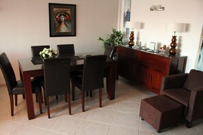 A dining area with a table, chairs, and a sofa.