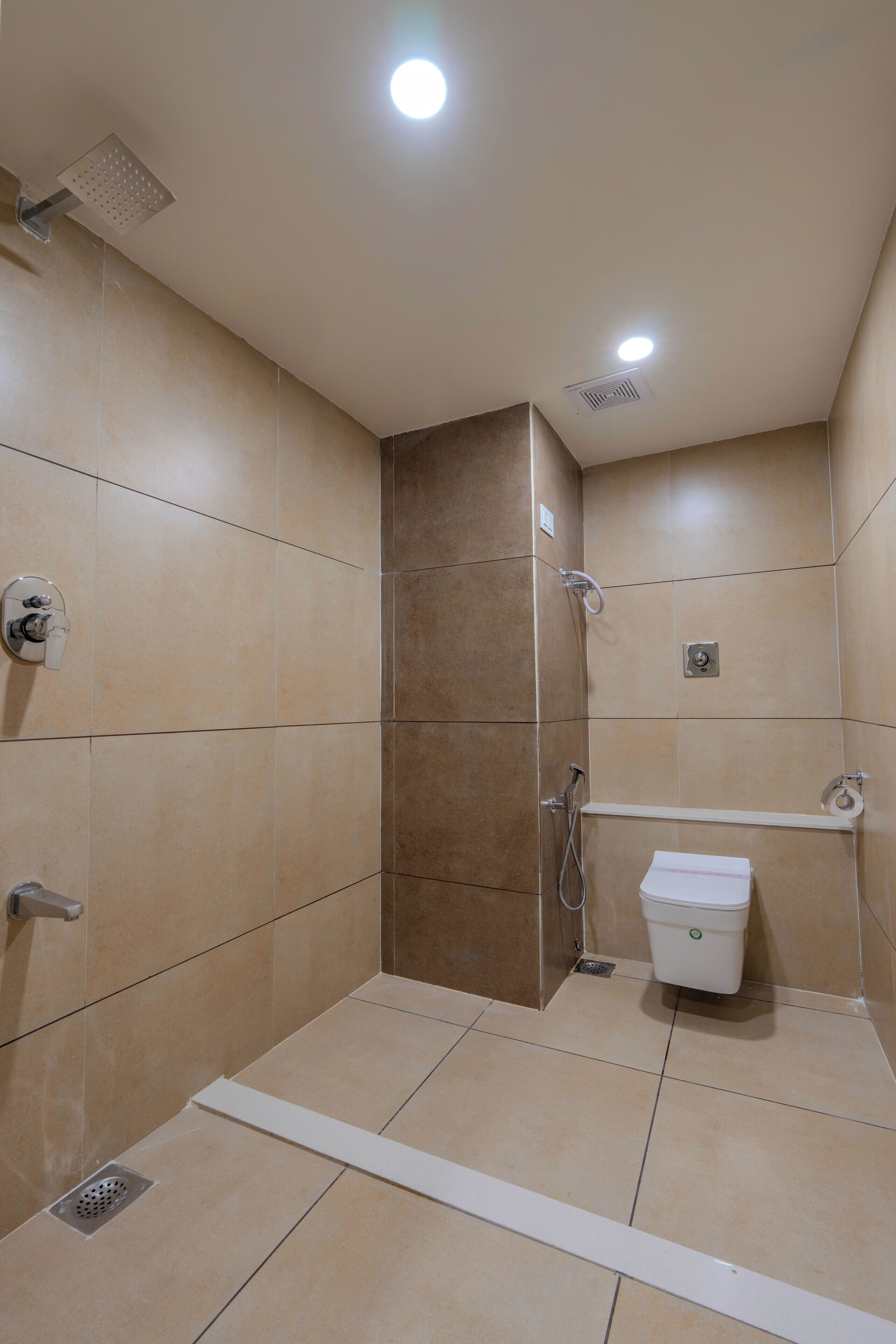 A small, enclosed shower area with a toilet and a shelf.