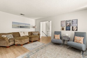 A living room with a sofa set, armchairs, a coffee table, and a rug. - 5BR San Antonio Home - Large Private Pool, Covered Patio, BBQ & Outdoor Games (San Antonio)