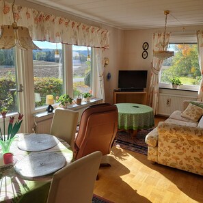A cozy living room with a TV, a dining table, and a sofa. - Våxtorp family villa near Vallåsens skidbacke och cykelpark (Våxtorp)