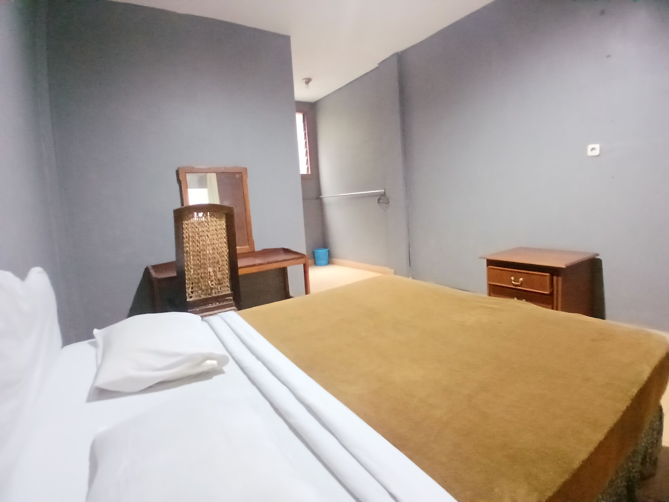 Un dormitorio con cama, cómoda, silla y mesita de noche.