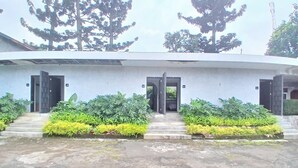 A building with two entrances, a concrete staircase, and a paved area in front. - Cibulan Indah Hotel (Cisarua)