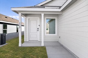A residential building with a white exterior, a front door, a small window, and a visible address number. - 3BR Near Gruene Historic District, Comal, and Guadalupe Rivers & Schlitterbahn (New Braunfels)