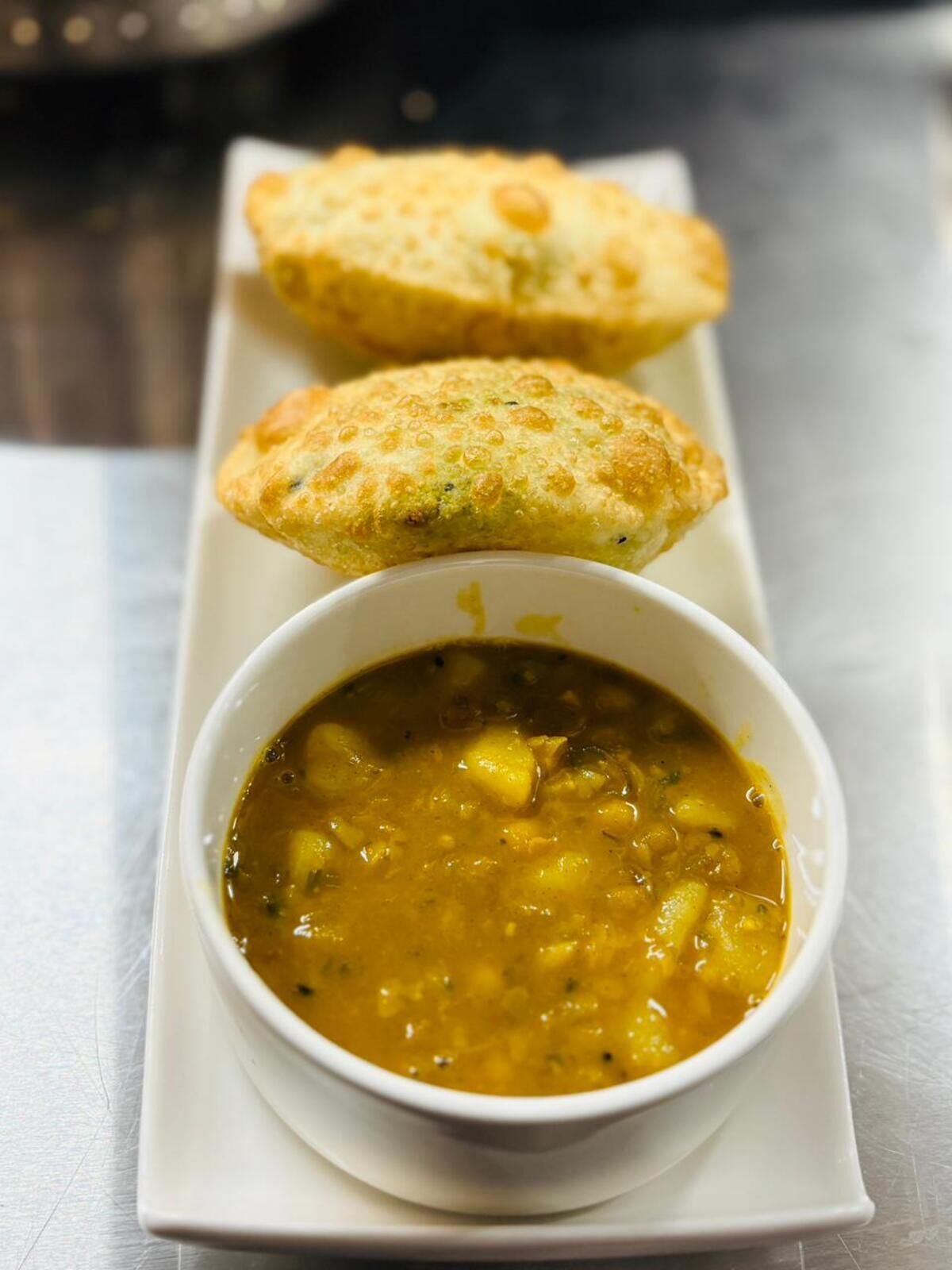 A dish of soup with bread on a white plate.