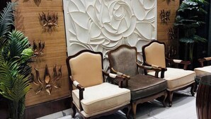 Een hal met twee fauteuils, een marmeren vloer en decoratieve wandpanelen.