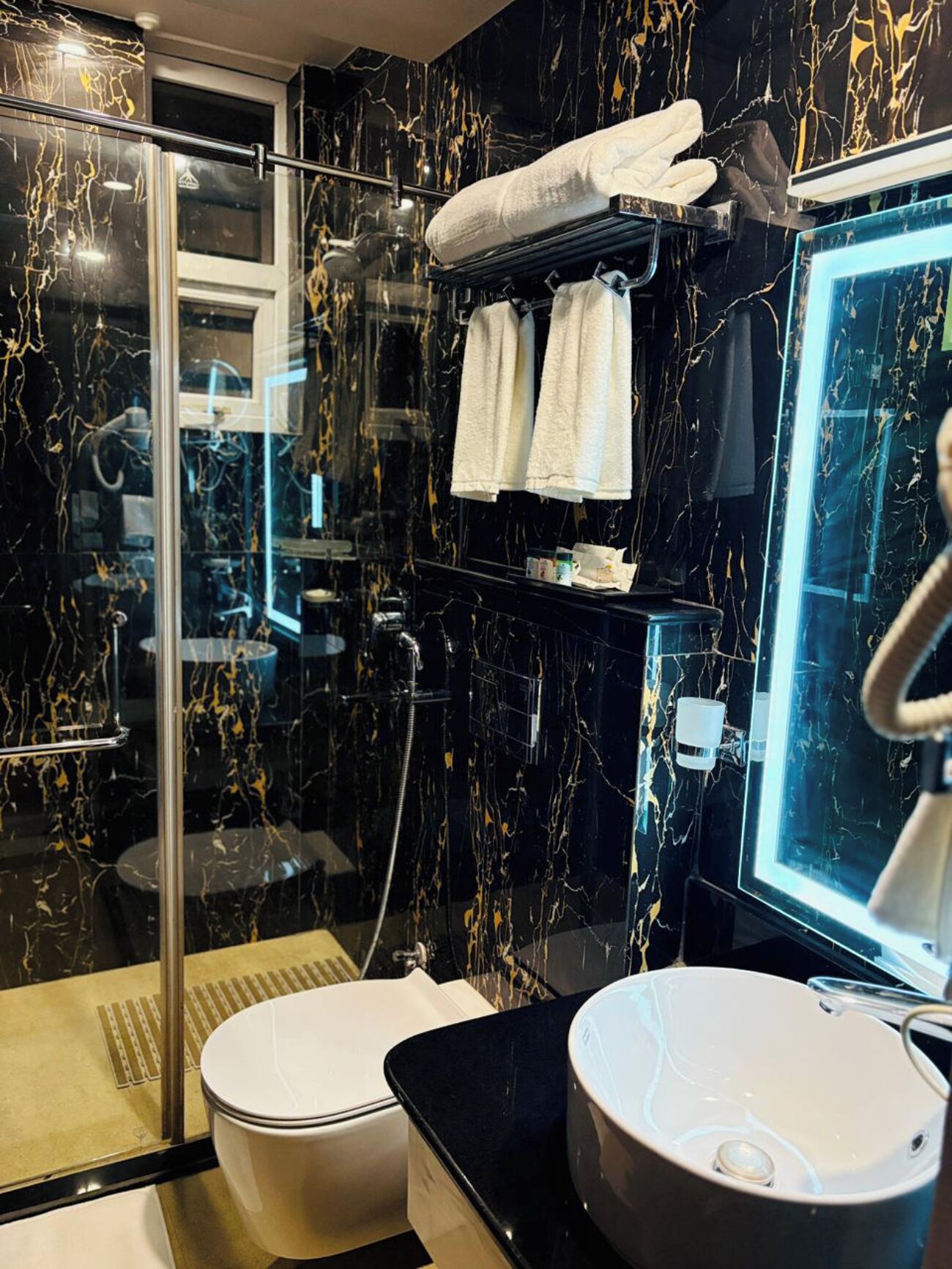 Une salle de bain moderne avec une douche à parois de verre, des toilettes et un lavabo avec un miroir.