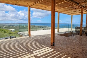 A spacious balcony with a clear view of the beach and ocean. - Buck Island Views · Villa + Heated Pool for 12 (Christiansted)