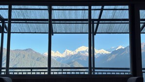 Una stanza con un'ampia finestra vista sulle montagne innevate.