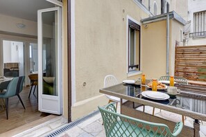 A dining area with a glass table, chairs, and breakfast items. - TBS 98 - Superb terrace apartment in Paris 15 (Paris)