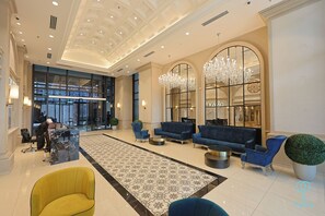 A spacious lobby with a central seating area, a reception desk, and a large window with a view of the outside. - Paxtonz by Mana Mana (Petaling Jaya)