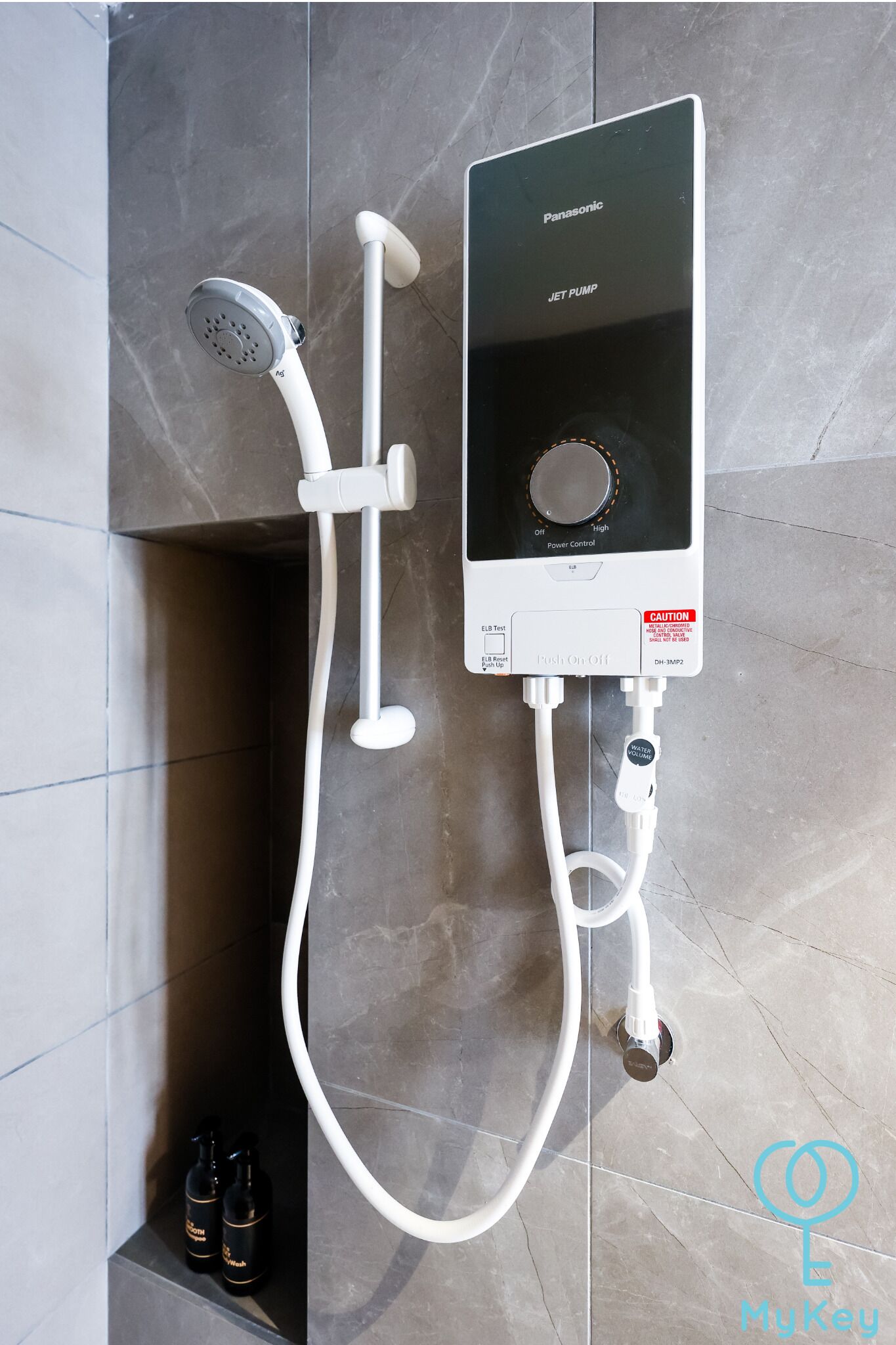 A Panasonic jet pump shower unit with a control panel, connected to a handheld showerhead.