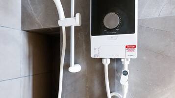 A Panasonic jet pump shower unit with a control panel, connected to a handheld showerhead.