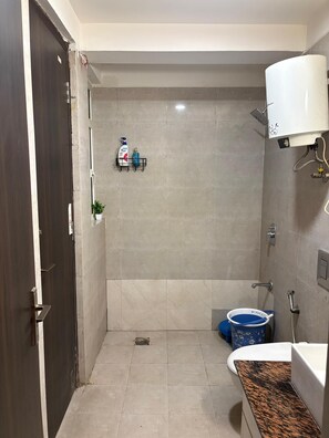 Een douche, handdoeken, zeep, toiletpapier