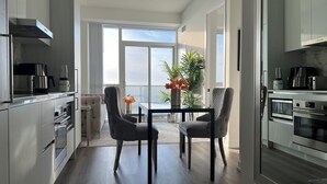 Une cuisine moderne avec un coin repas, de grandes fenêtres et une vue sur la mer.