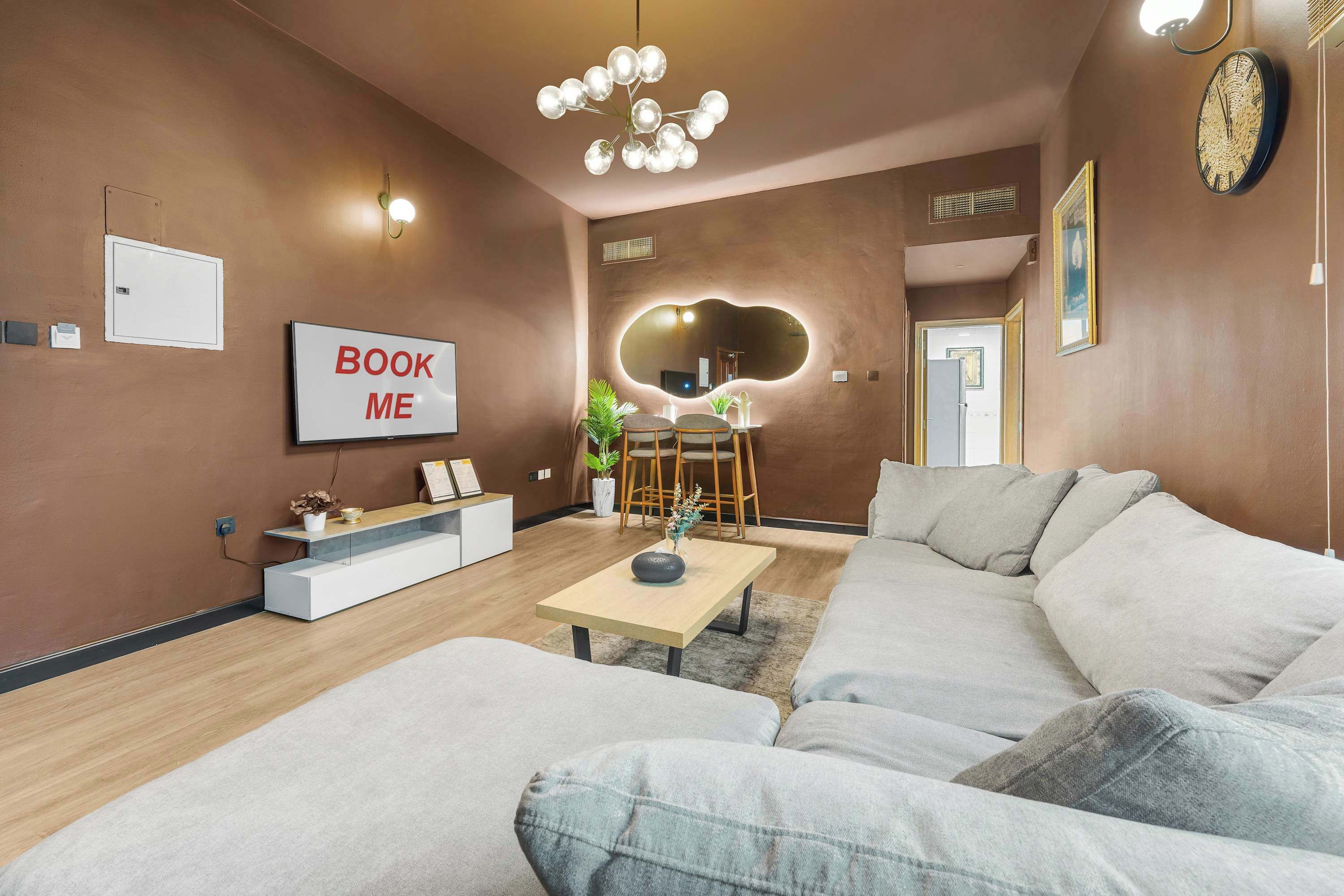 Un salon moderne avec un canapé, une table basse, un téléviseur et un panneau indiquant « Réservez-moi ».