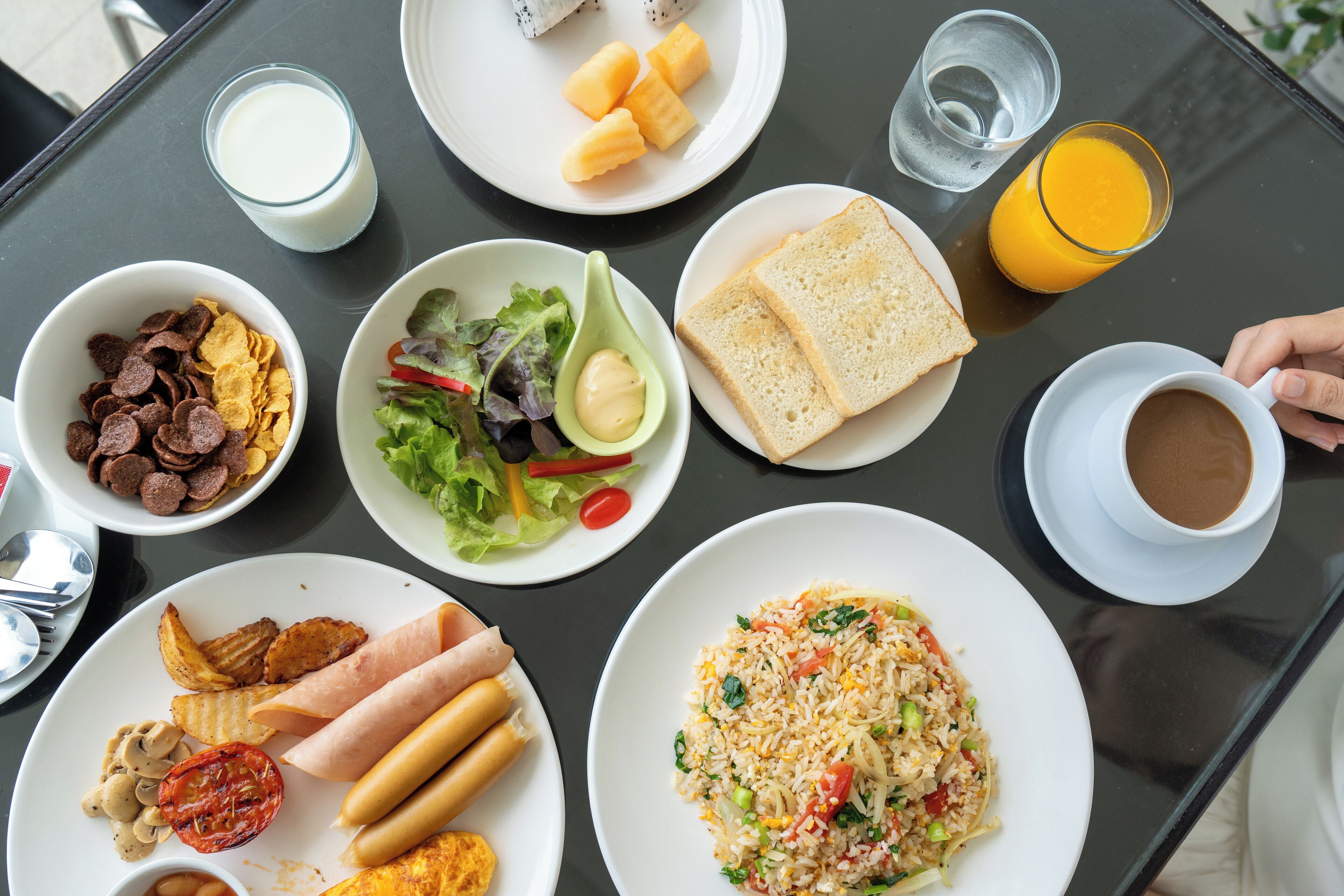 A table with various breakfast items including cereal, toast, eggs, and a salad.