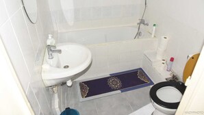 Une salle de bain avec un lavabo, des toilettes et une baignoire.