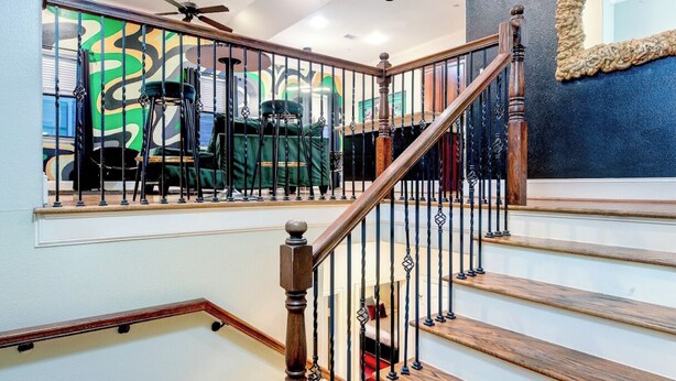 Una escalera con escalones de madera y barandillas de metal negro.