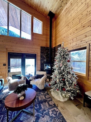Una habitación acogedora con chimenea, un árbol de Navidad y una pared de piedra.