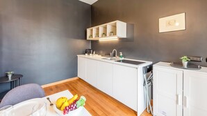 Een moderne keuken met witte kastjes, een geïntegreerde gootsteen en een aanrecht met een fruitschaal.