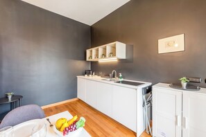 A modern kitchen with white cabinets, a built-in sink, and a countertop with a fruit bowl. - Piazza Rossetti Apartments (Genoa)