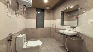 A modern bathroom with a toilet, sink, and shower. - Sky Bird Nest (Manali)