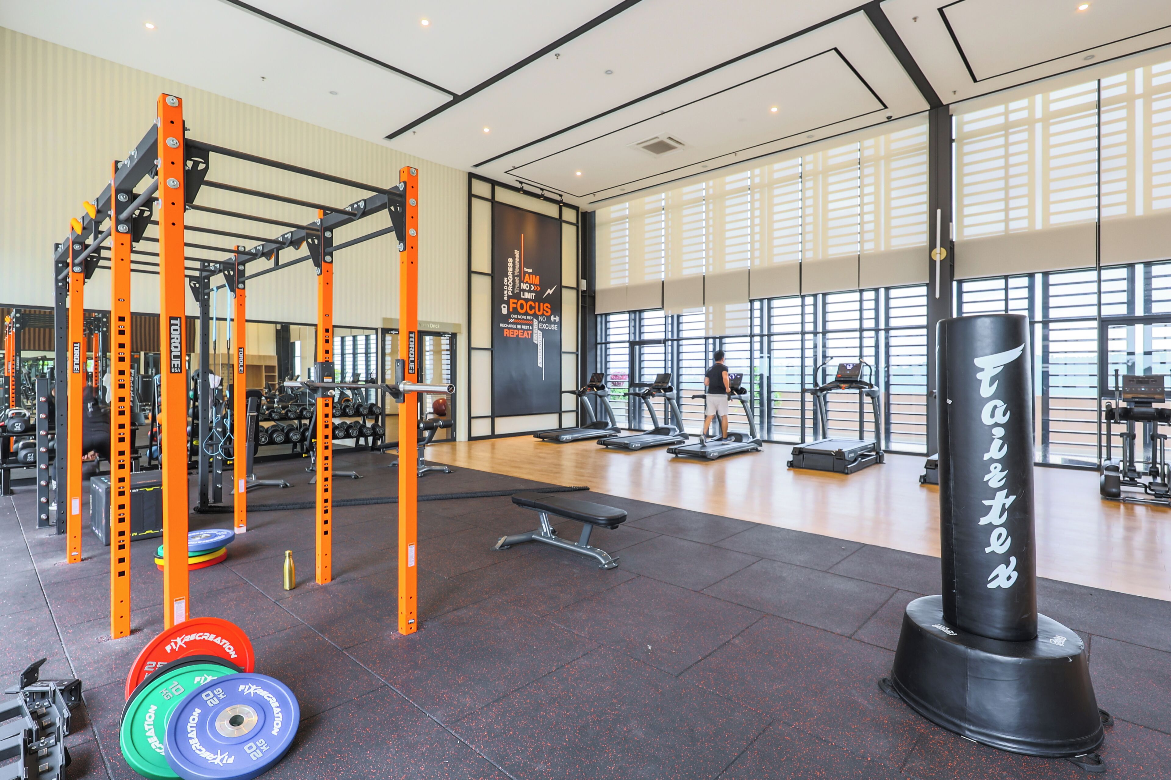 A gym with weightlifting equipment, treadmills, and a punching bag.