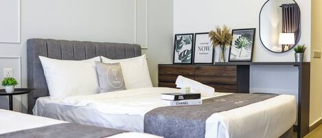 Una habitación de hotel moderna con una cama grande, una mesita de noche con lámpara y cuadros en la pared.
