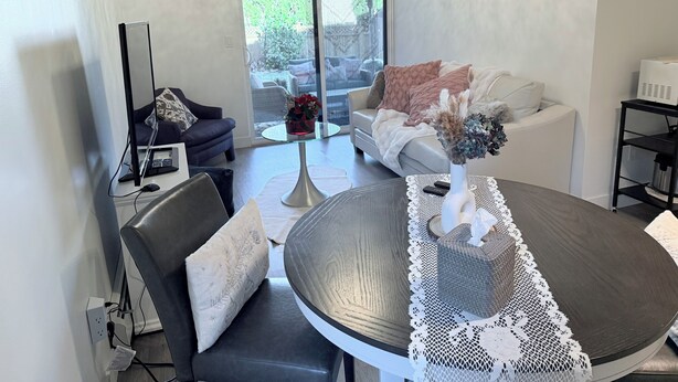 Un salon moderne avec une table de salle à manger ronde, un canapé et une table basse avec un plateau en verre.