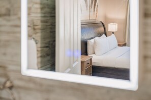Ein Hotelzimmer mit Bett, Nachttischlampe und einem Holznachttisch.
