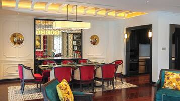 Un'area pranzo con un tavolo rotondo e sedie rosse, un soggiorno con divani color acquamarina e tappeti decorati, e un moderno design del soffitto con illuminazione a incasso.