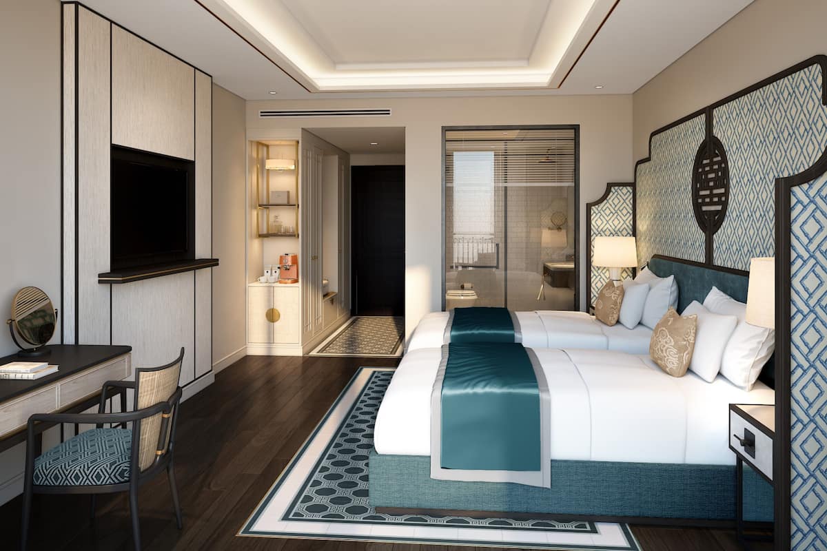 Ein modernes Hotelzimmer mit einem großen Bett, einem Schreibtisch und einem Fernseher.