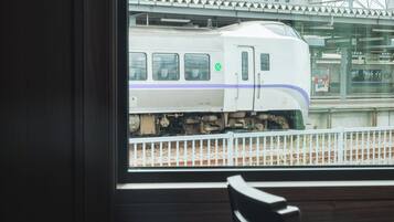 A train station view through a window with a chair inside.