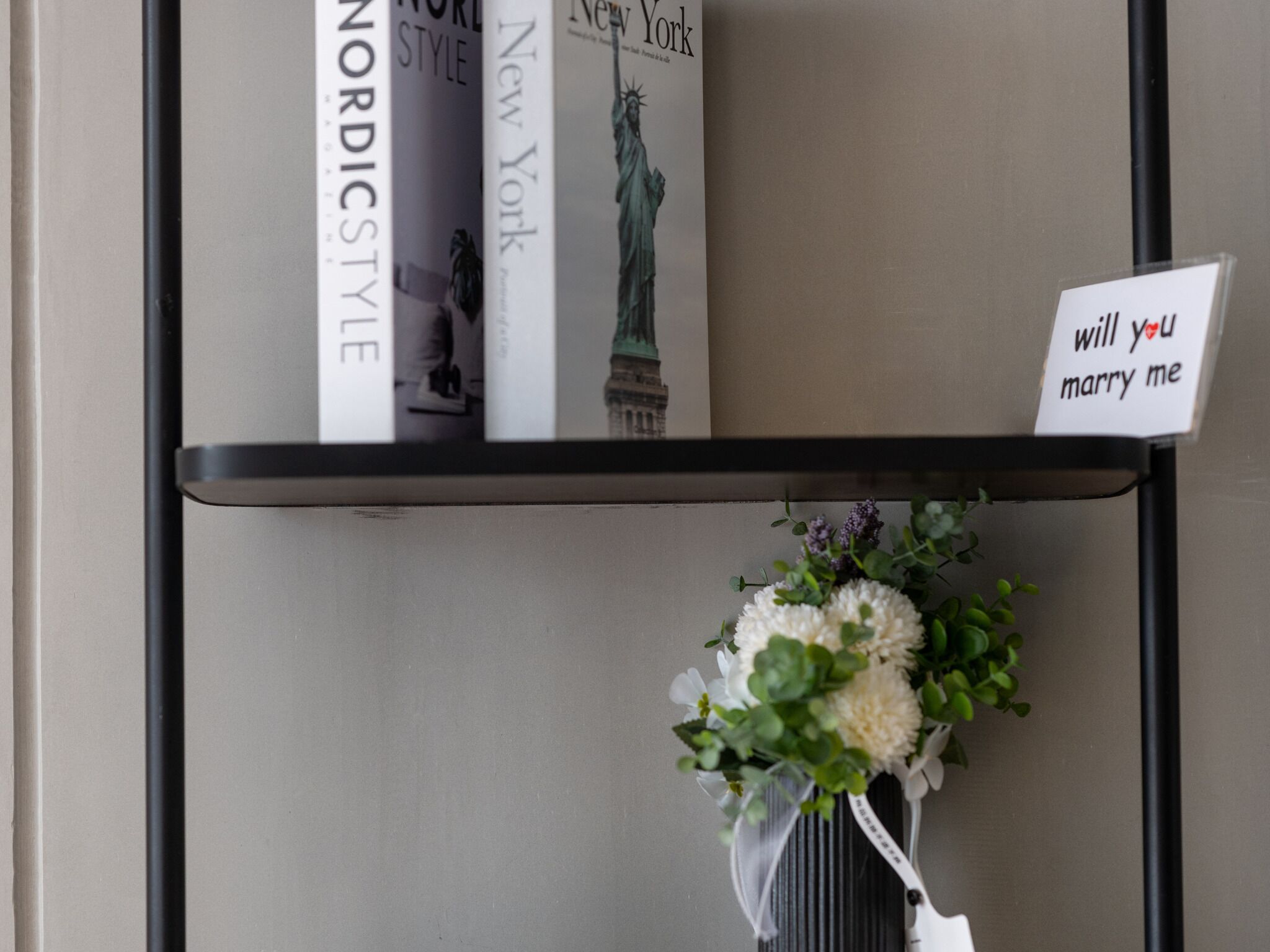 A bookshelf with books and a small sign.