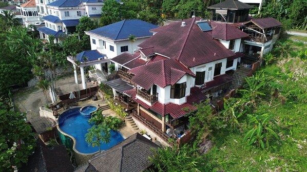 A large house with a swimming pool, multiple balconies, and a lush garden. - Serene Palm Heritage Tropical Villa (Taman Melawati)