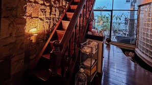 Eine Treppe mit Holzgeländern und Steinmauern, die zu einem Balkon mit Aussicht führt.