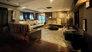 Ein modernes Wohnzimmer mit einer Sofagarnitur, einem Couchtisch und einem Fernseher.