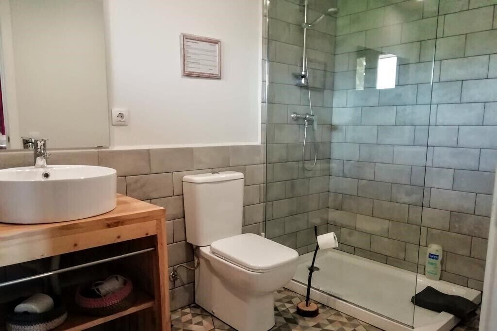 Et badeværelse med vask, toilet og bruseniche.