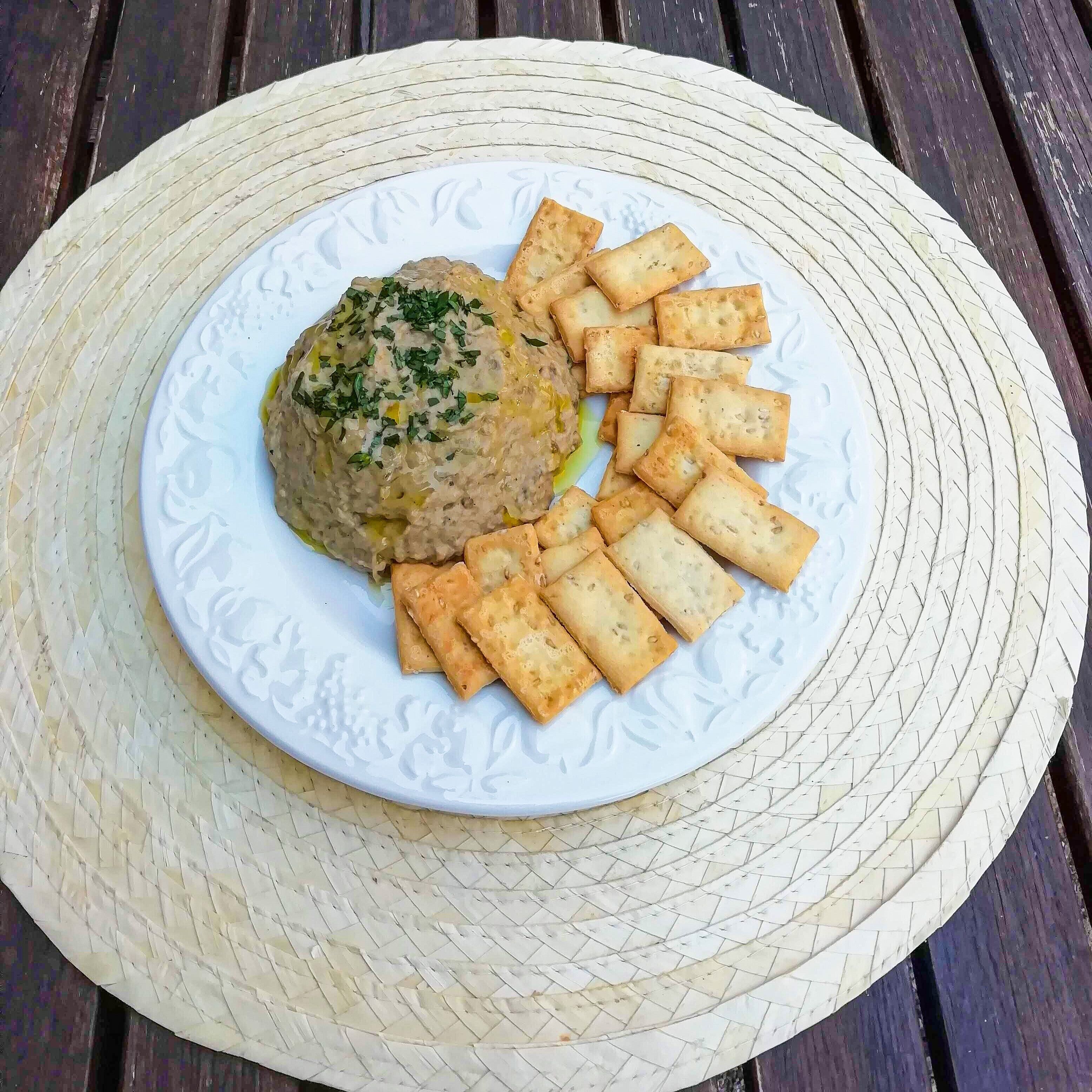 Un plato de comida sobre un plate blanco con textura y un tapete tejido debajo.