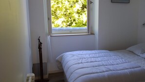 Ein Schlafzimmer mit Bett, Fenster und Tür.