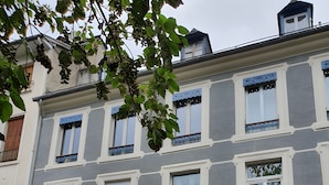 Ein mehrstöckiges Gebäude mit einem Balkon, einer Holztür und der Hausnummer 17 an der Fassade.