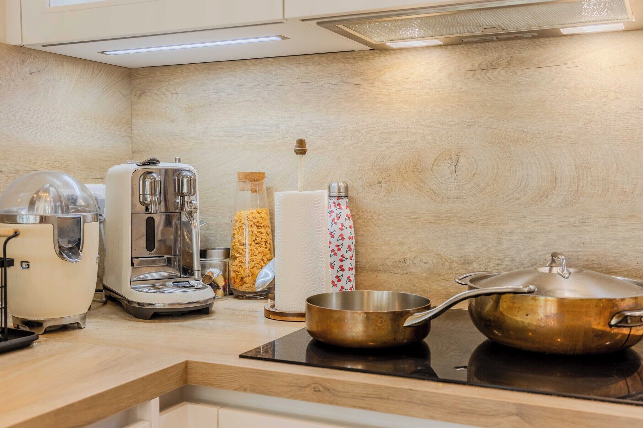 A kitchen with a toaster, coffee maker, and a pot on a stove.
