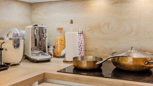 Una cucina con un tostapane, una macchina da caffè e una pentola su un fornello.