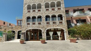 Ein Steinhaus mit mehreren Balkonen und großen Fenstern.