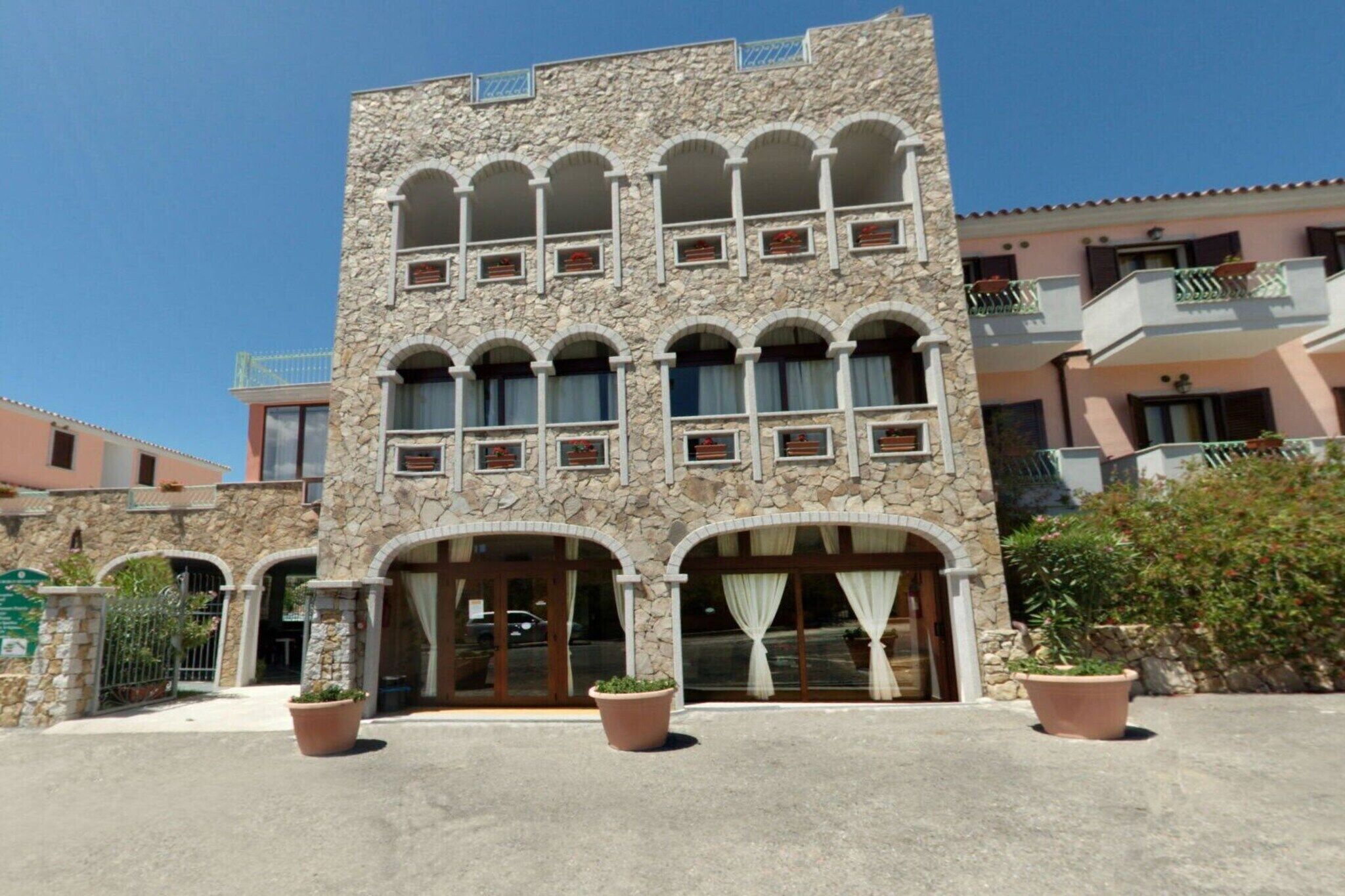 Ein Steinhaus mit mehreren Balkonen und großen Fenstern.