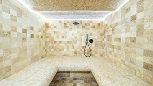 Eine Sauna mit Wänden und Bänken aus Mosaikfliesen.